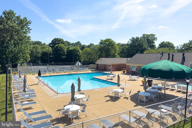 community pool featuring fence and a patio
