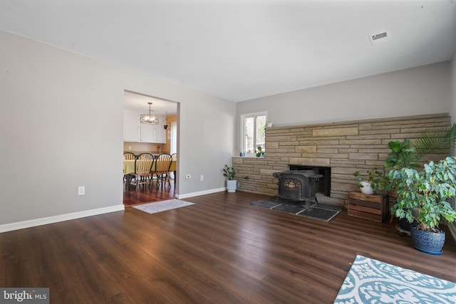 1513 Millikens Bend Rd, Herndon, VA 20170 - living room featuring a wood stove, wood finished floors, baseboards, and a chandelier