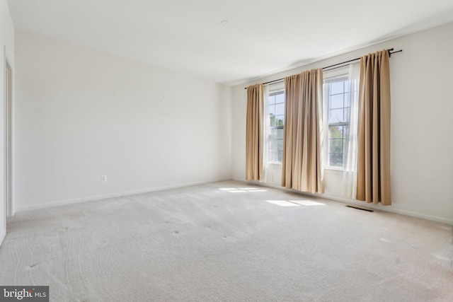 unfurnished room featuring baseboards, visible vents, and carpet flooring