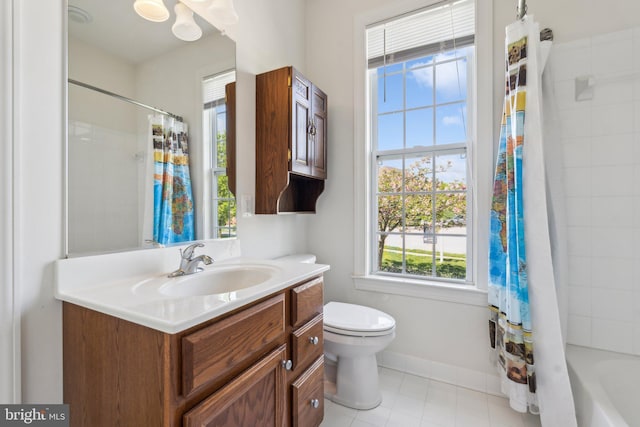 bathroom featuring tile patterned floors, toilet, vanity, baseboards, and shower / bath combo