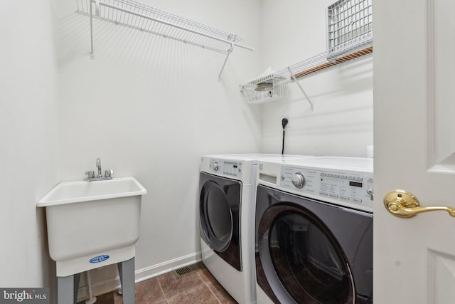 washroom with washing machine and clothes dryer, laundry area, and baseboards