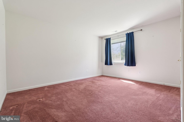 carpeted empty room with baseboards