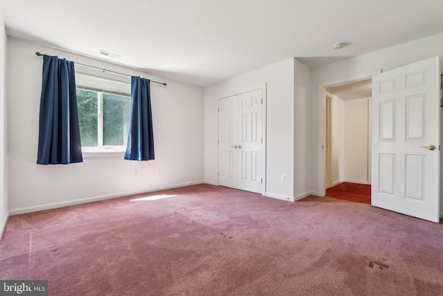 unfurnished bedroom with visible vents, baseboards, carpet, and a closet