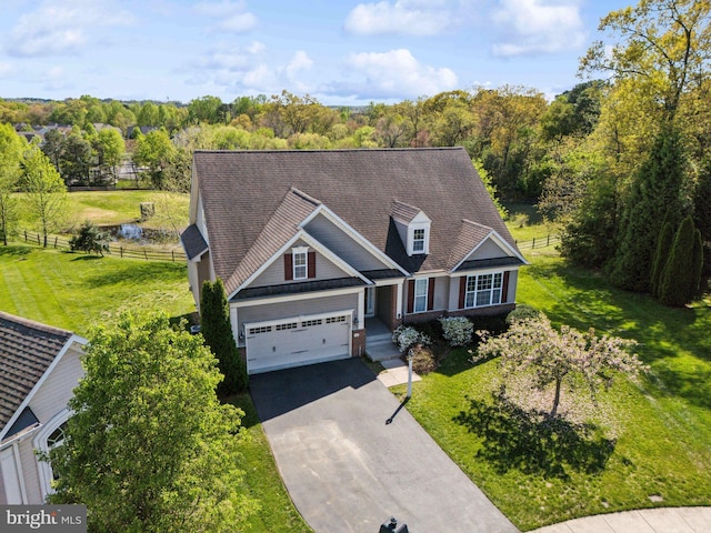 view of front of home featuring aphalt driveway, fence, a garage, and a front yard
