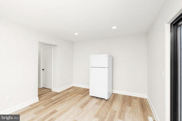 spare room featuring recessed lighting, baseboards, and light wood-type flooring