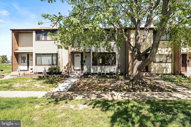 townhome / multi-family property with a front lawn