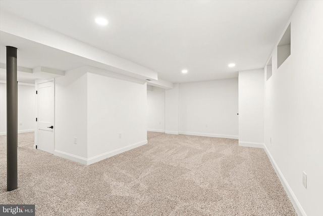 finished basement featuring baseboards, light carpet, and recessed lighting