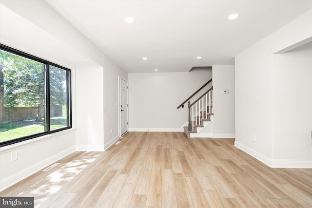 empty room with visible vents, stairs, light wood-style floors, baseboards, and recessed lighting