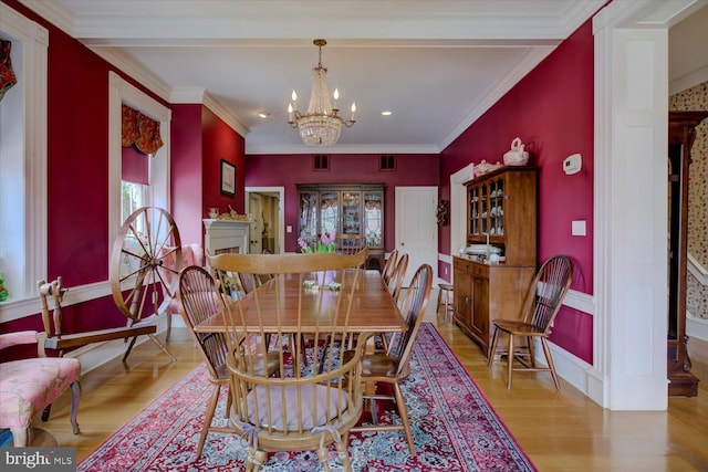dining area with a chandelier, recessed lighting, wood finished floors, and ornamental molding