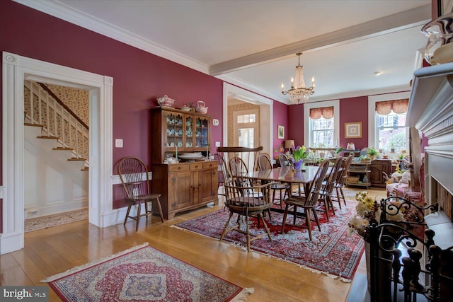 dining room with crown molding, baseboards, an inviting chandelier, wood finished floors, and stairs