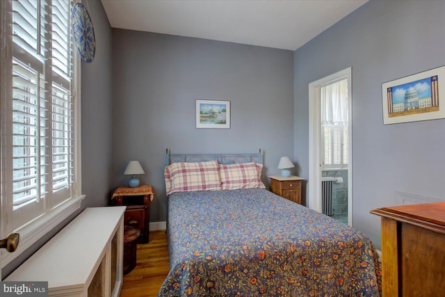 bedroom featuring multiple windows, wood finished floors, and baseboards