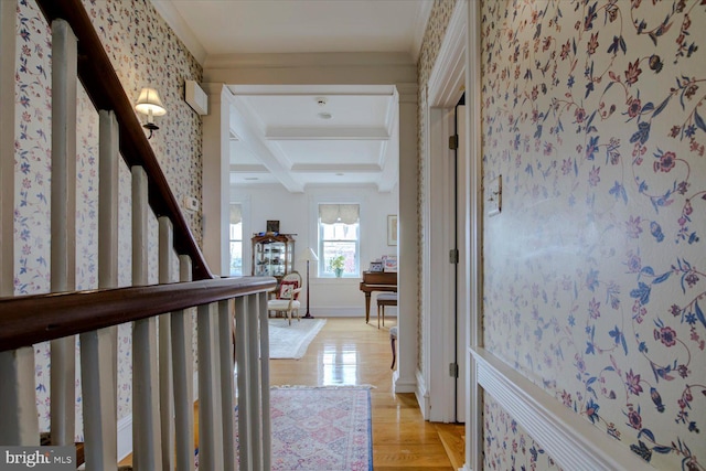 hall featuring stairway, coffered ceiling, wallpapered walls, beam ceiling, and light wood finished floors