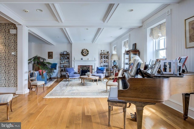 sitting room featuring beam ceiling, wood finished floors, coffered ceiling, and a brick fireplace