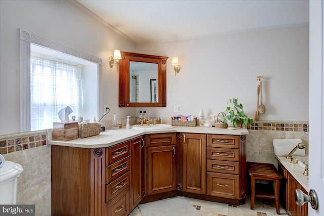 bathroom with tile walls, a wainscoted wall, crown molding, and vanity