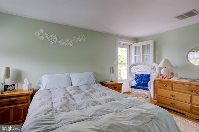 bedroom with visible vents, wood finished floors, and multiple windows