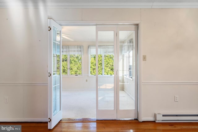 entryway with a baseboard radiator, baseboards, a ceiling fan, and wood finished floors