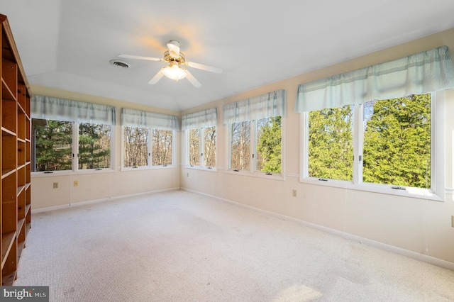 unfurnished sunroom with baseboards, visible vents, carpet floors, and a healthy amount of sunlight