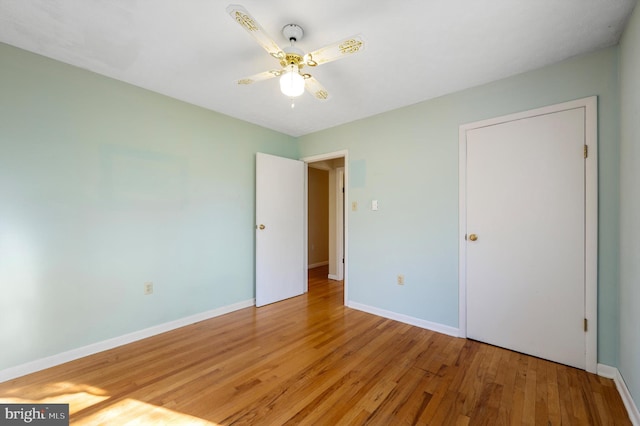 unfurnished bedroom with light wood-style flooring, baseboards, and a ceiling fan