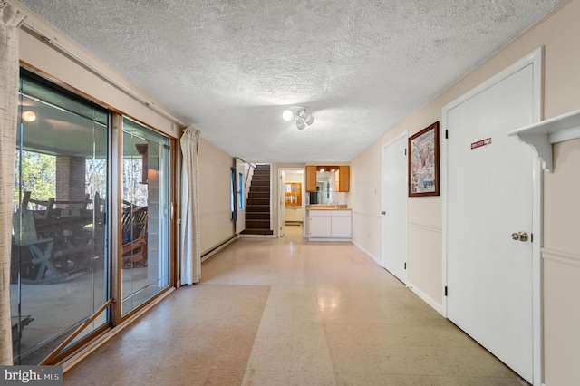 hallway with light floors, stairs, a textured ceiling, and baseboard heating