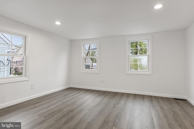 spare room with a wealth of natural light, recessed lighting, and baseboards