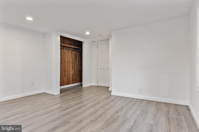 unfurnished bedroom featuring a closet, baseboards, recessed lighting, and wood finished floors
