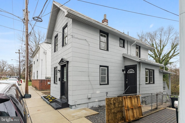 view of front of house featuring fence and a chimney
