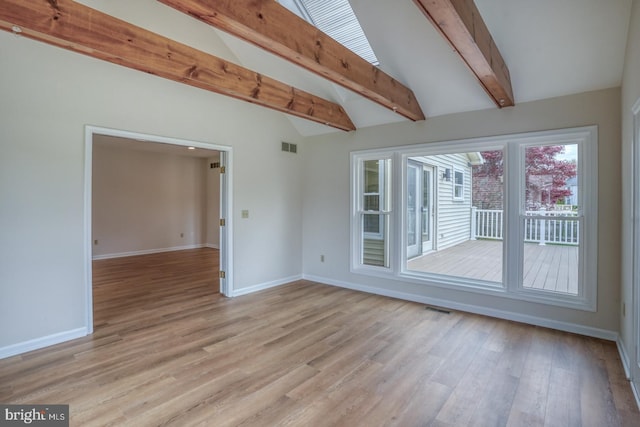 unfurnished room with visible vents, baseboards, lofted ceiling with beams, and light wood finished floors
