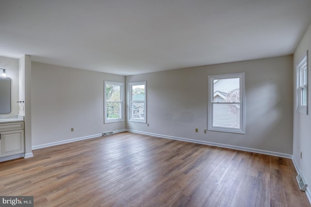 interior space with baseboards, visible vents, and light wood finished floors