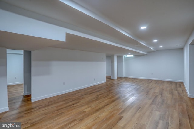 finished below grade area with recessed lighting, baseboards, and light wood-style flooring