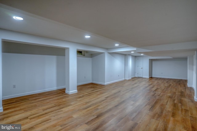 finished below grade area with recessed lighting, baseboards, and light wood-style floors