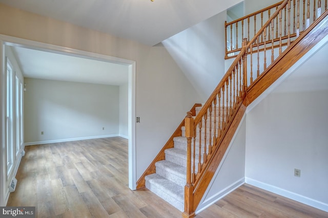 stairway with baseboards and wood finished floors