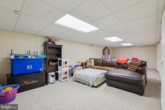 living room featuring carpet flooring and a drop ceiling