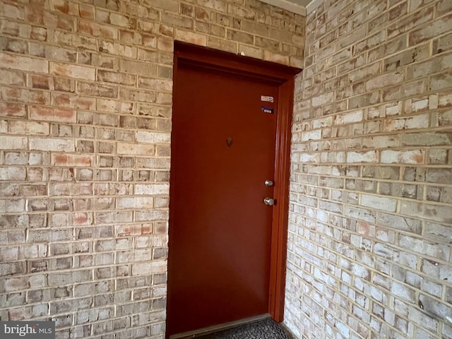 doorway to property with brick siding