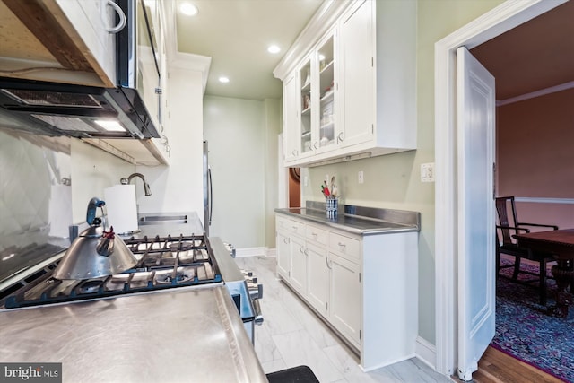 kitchen featuring glass insert cabinets, white cabinets, recessed lighting, and stainless steel countertops