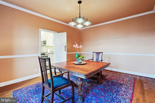 dining room with baseboards, ornamental molding, and hardwood / wood-style flooring