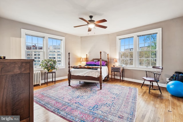 bedroom with radiator, wood-type flooring, and baseboards