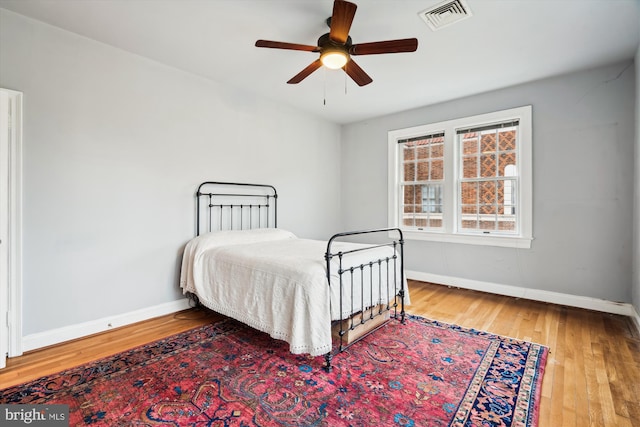 bedroom featuring wood-type flooring, visible vents, and baseboards