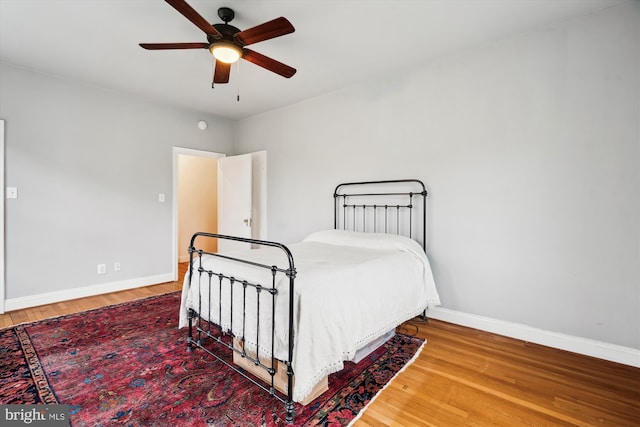 bedroom with baseboards, a ceiling fan, and wood finished floors