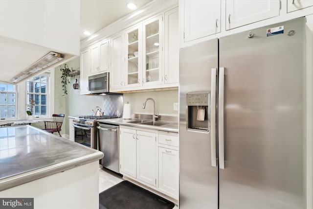 kitchen featuring a sink, white cabinetry, stainless steel countertops, and stainless steel appliances