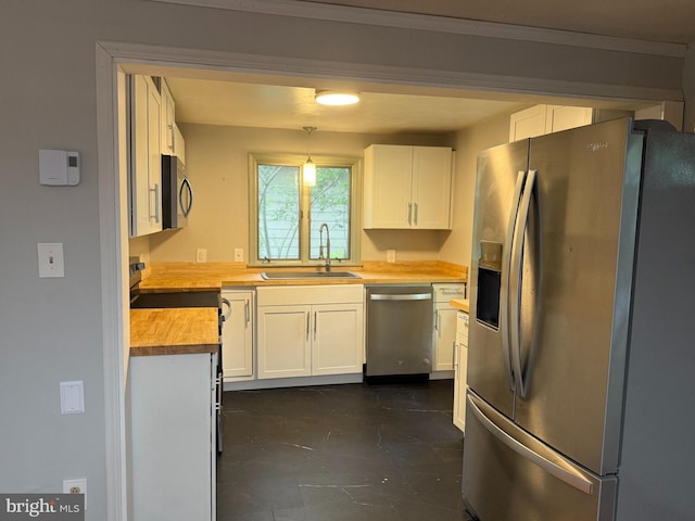 619 Cannon St, Chestertown, MD 21620 - kitchen featuring butcher block countertops, hanging light fixtures, a sink, white cabinets, and appliances with stainless steel finishes