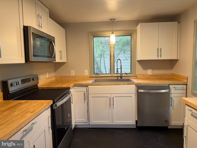 619 Cannon St, Chestertown, MD 21620 - kitchen with a sink, stainless steel appliances, white cabinets, decorative light fixtures, and butcher block counters