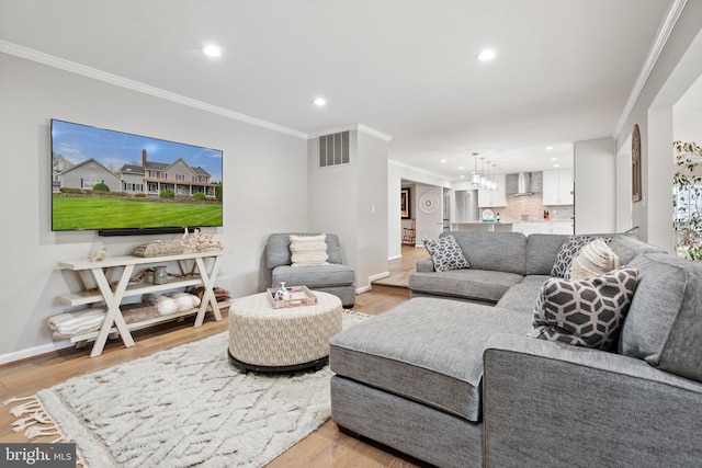 living room featuring recessed lighting, light wood finished floors, and ornamental molding