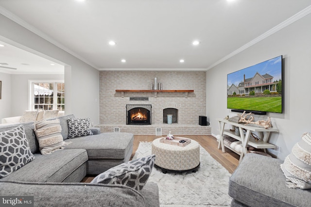 living area featuring recessed lighting, a brick fireplace, ornamental molding, and wood finished floors