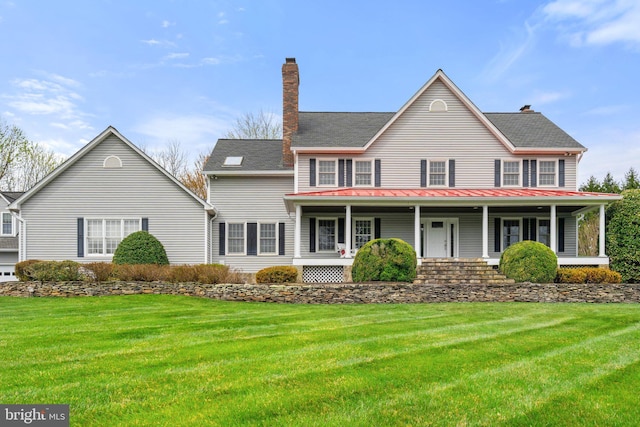 view of front of house with a porch, a chimney, and a front lawn