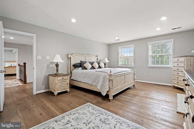 bedroom featuring baseboards, visible vents, and hardwood / wood-style flooring