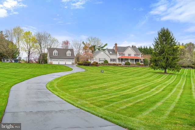 view of front of house featuring a garage, driveway, and a front lawn