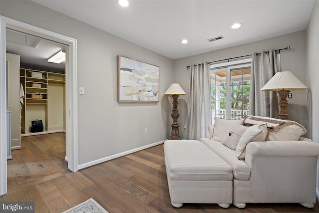 sitting room featuring wood finished floors, baseboards, visible vents, and recessed lighting