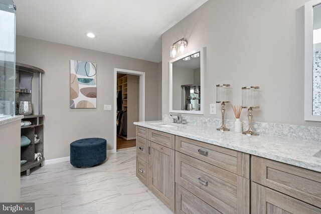 full bath with vanity, baseboards, a spacious closet, recessed lighting, and marble finish floor