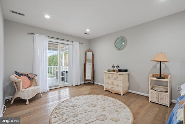 sitting room featuring visible vents, baseboards, and wood finished floors