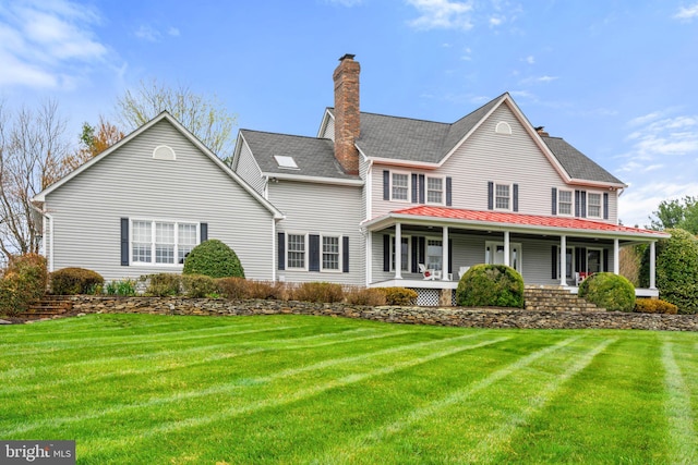 view of front of property featuring a front yard, a porch, and a chimney